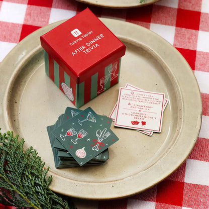 After Dinner Trivia game box and cards on a plate with a red and white checkered tablecloth.