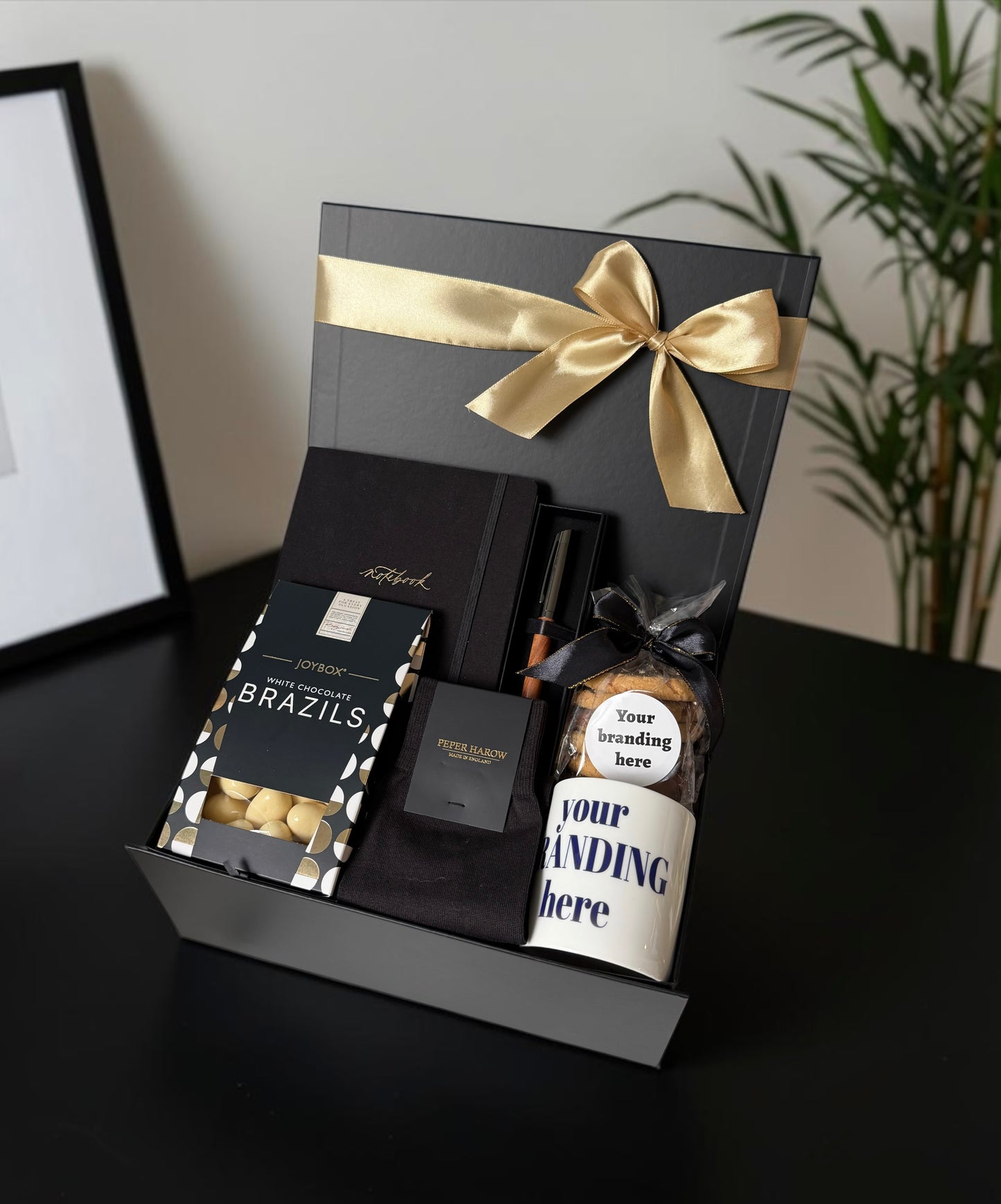 Corporate new starter gift hamper with notebook, personalised pen, socks, chocolates, branded mug and biscuits.