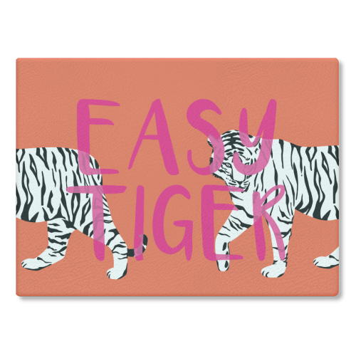 Easy Tiger Glass Chopping Board with tiger pattern on orange background.
