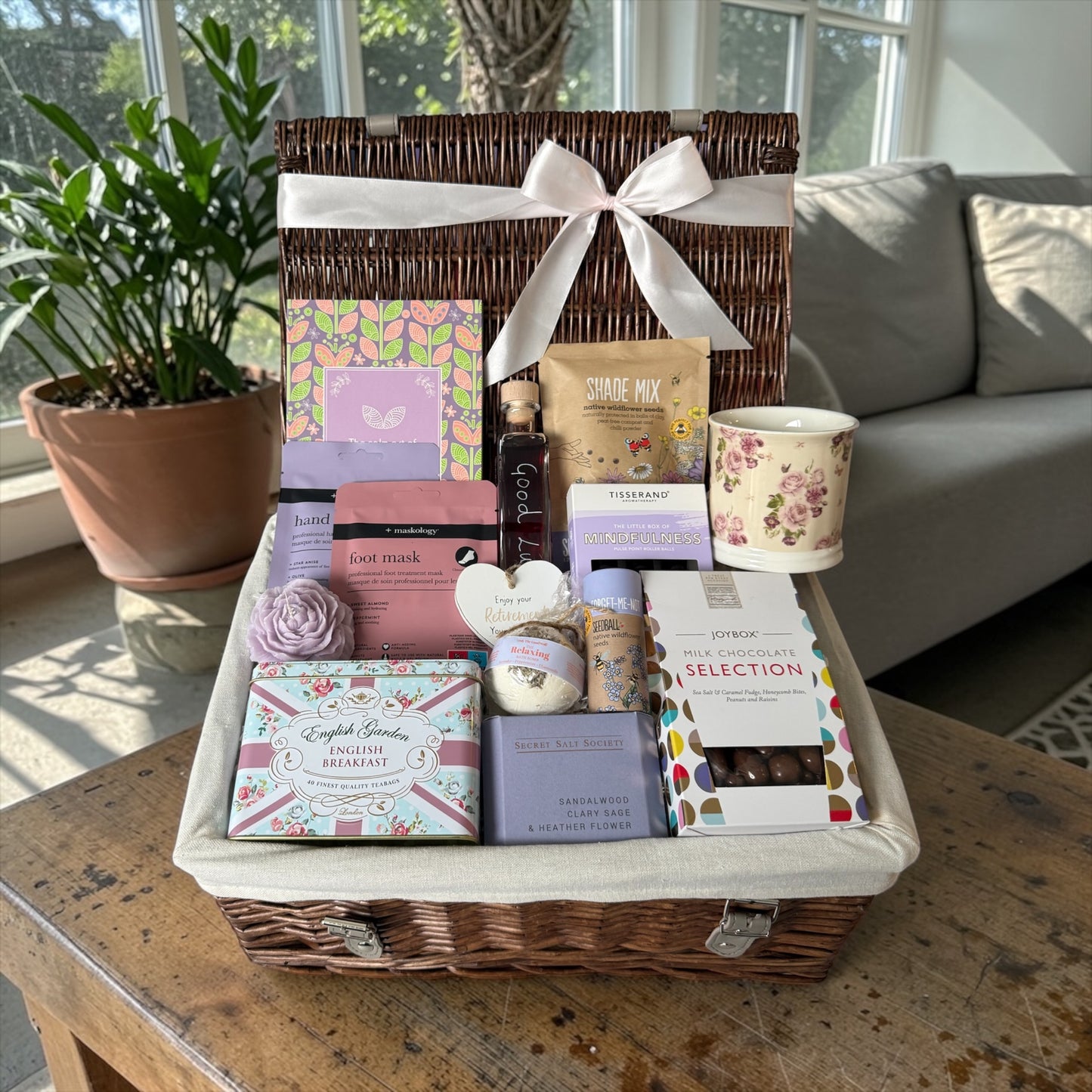 Retirement gift hamper with tea, chocolates, candle, bath treats, seedballs and bramble whisky liqueur.
