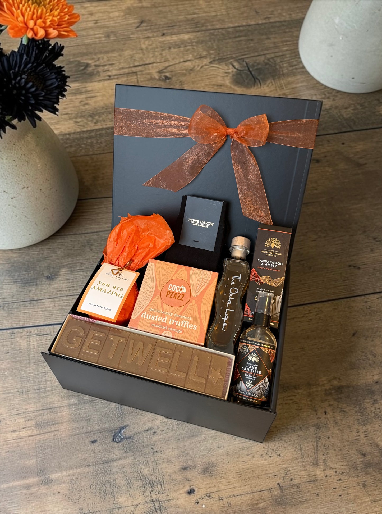 Get well gift hamper with truffles, rhubarb gin liqueur, hand cream, diffuser or bath bomb and Peper Harow socks.