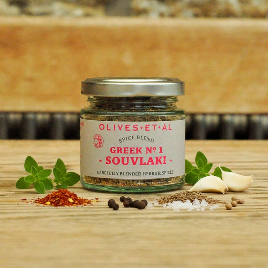 Jar of Olives et al Spice Blend Greek No 1 Souvlaki on a wooden surface with herbs and spices.