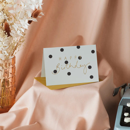 Happy Birthday gold foil grey polka dot card on display.