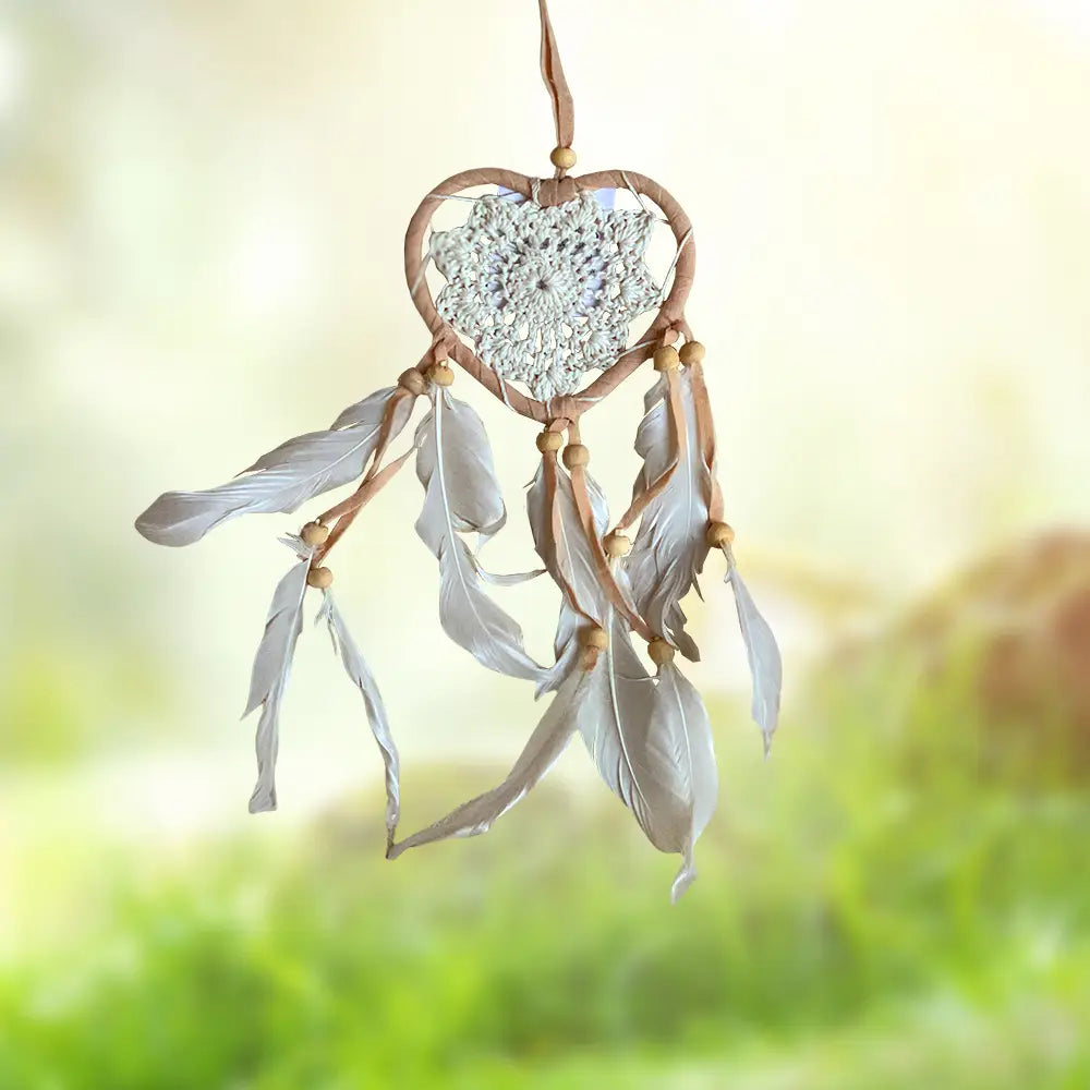 Heart-shaped dream catcher with feathers and beads.