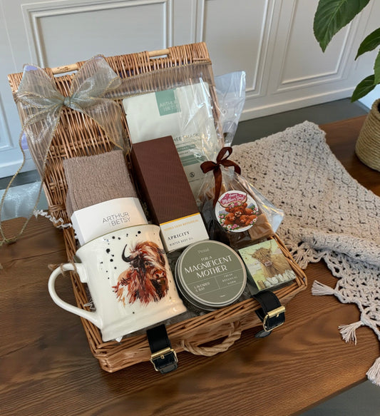 Gift basket with a mug, socks, candle, body oil, fudge, face mask and lip balm with cows