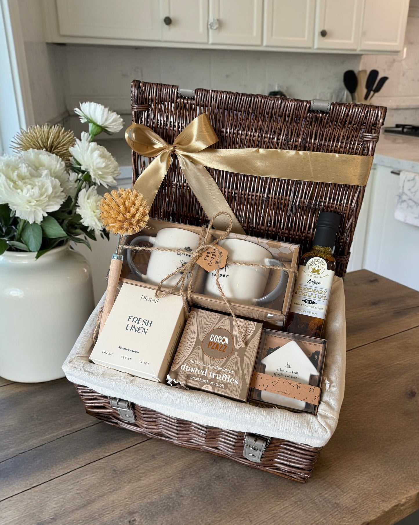 new home Gift basket with a variety of items on a wooden surface in a kitchen setting.