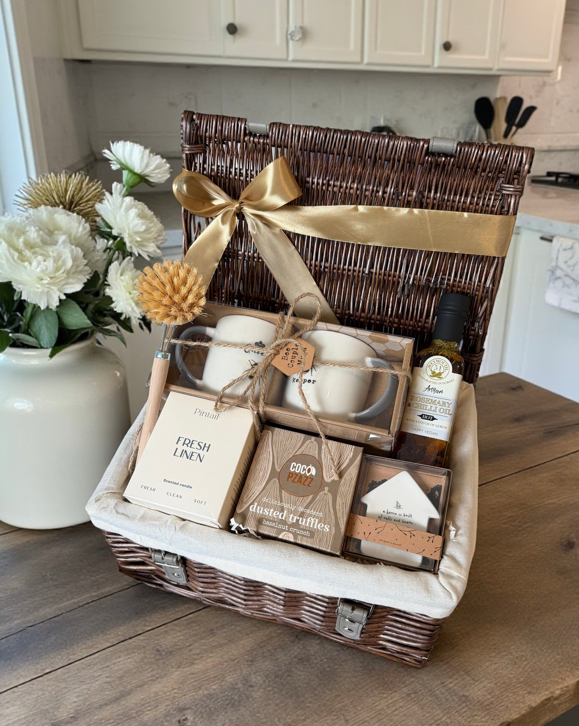 new home Gift basket with a variety of items on a wooden surface in a kitchen setting.