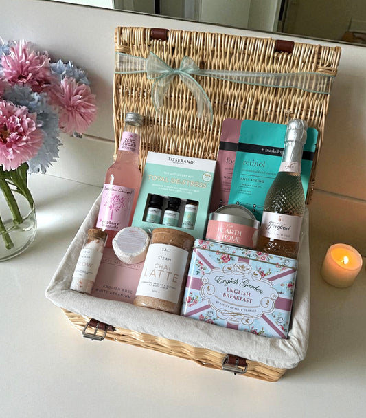 Indulgent De-Stress Hamper with rosé fizz, tea, candle, chai blend, face masks, bath soak, and wellness treats – luxury pamper gift.