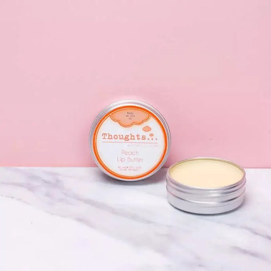 Handmade vegan lip butter peach 15ml in open tin against pink background.
