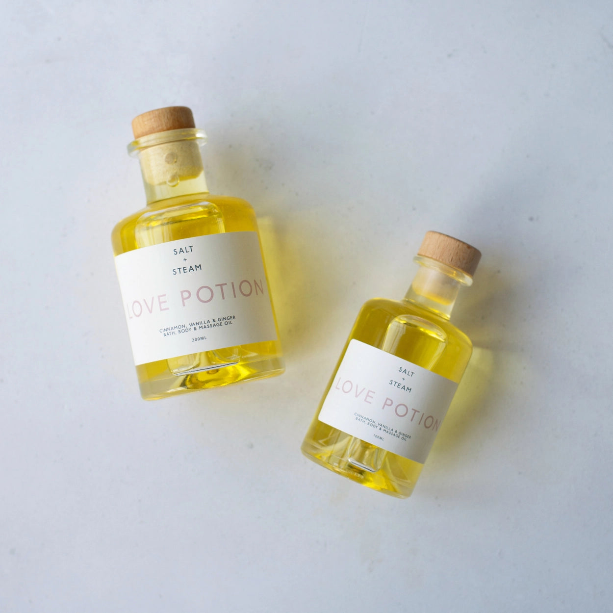 Two bottles of 'Love Potion' bath, body and massage oil