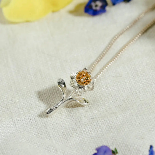 elegant daffodil pendant in silver and gold with detailed petals.  