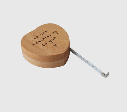 Heart-shaped measuring tape with "No One Measures Up To You" engraved.