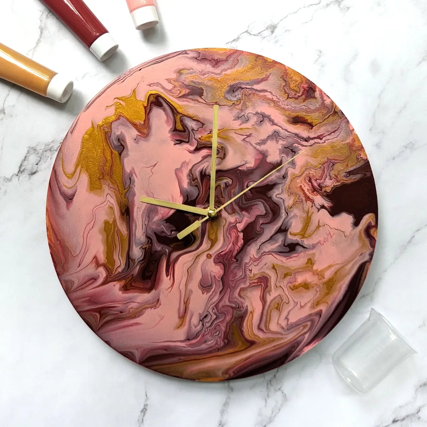 Paint Pouring Wall Clock with golden hands and acrylic background in a craft kit.