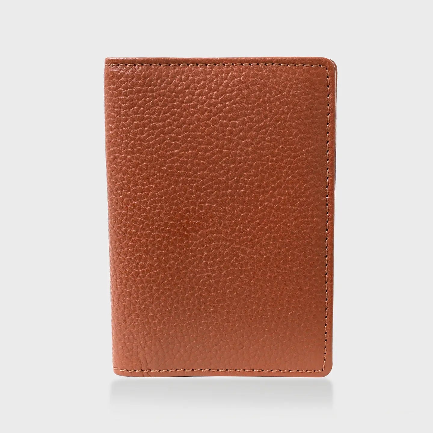 Pebble grain leather passport holder in tan.
