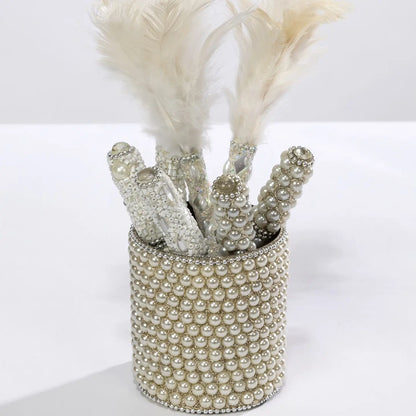 Beaded pearl pens with feathers in a pearl-embellished holder.