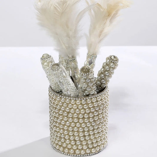 Beaded pearl pens with feathers in a pearl-embellished holder.