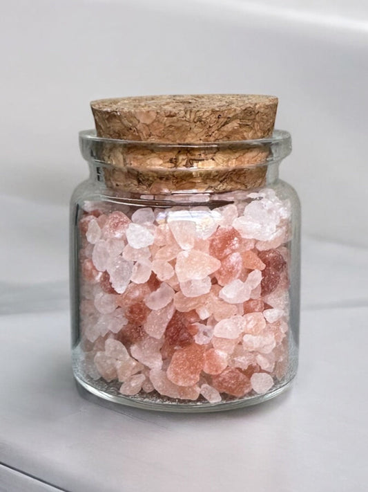 Himalayan Pink Rock Salt in a small glass jar with cork lid.