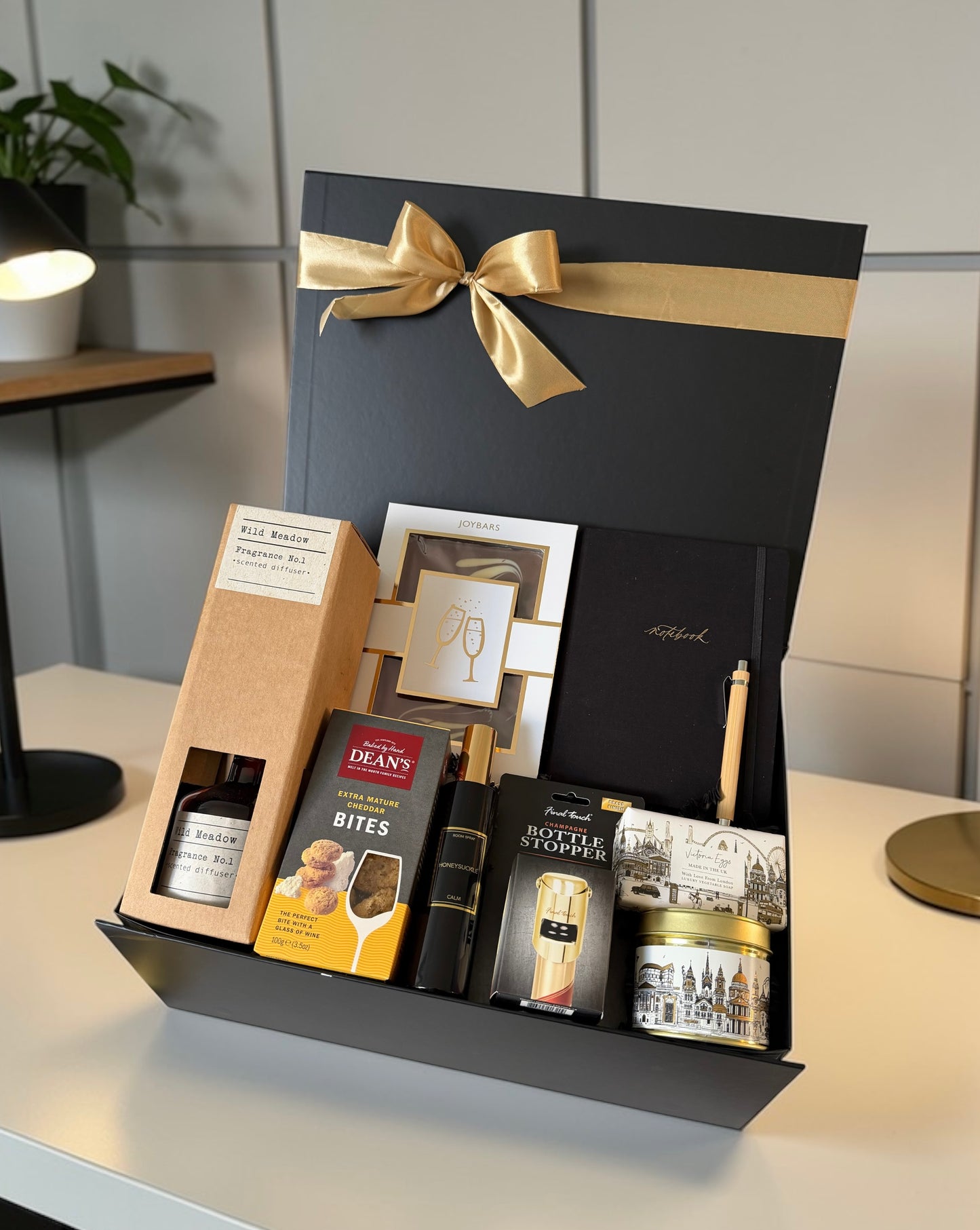 Premium congratulations gift hamper with chocolate, notebook, reed diffuser, gourmet cheese bites.