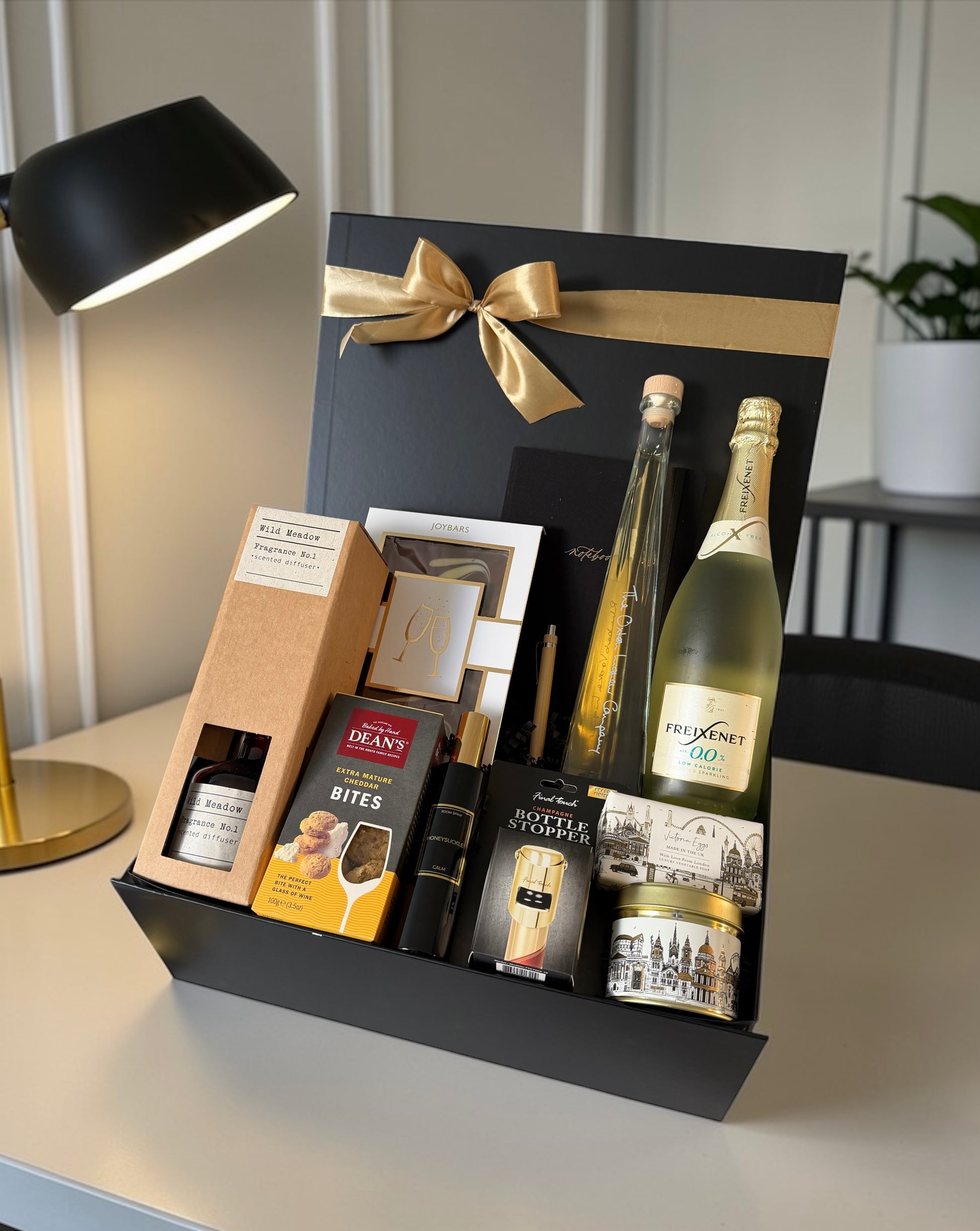 Premium congratulations gift hamper with chocolate, notebook, reed diffuser, gourmet cheese bites, rhubarb vodka liqueur and bottle option.