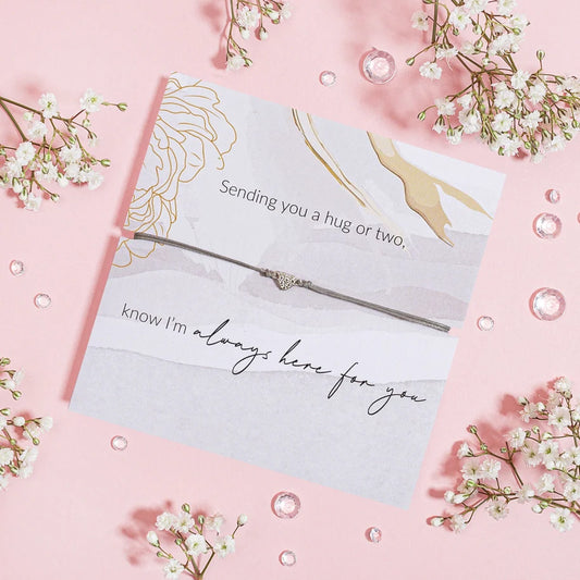 Thoughtful "Sending Hugs" Bracelet displayed on a card with floral accents.