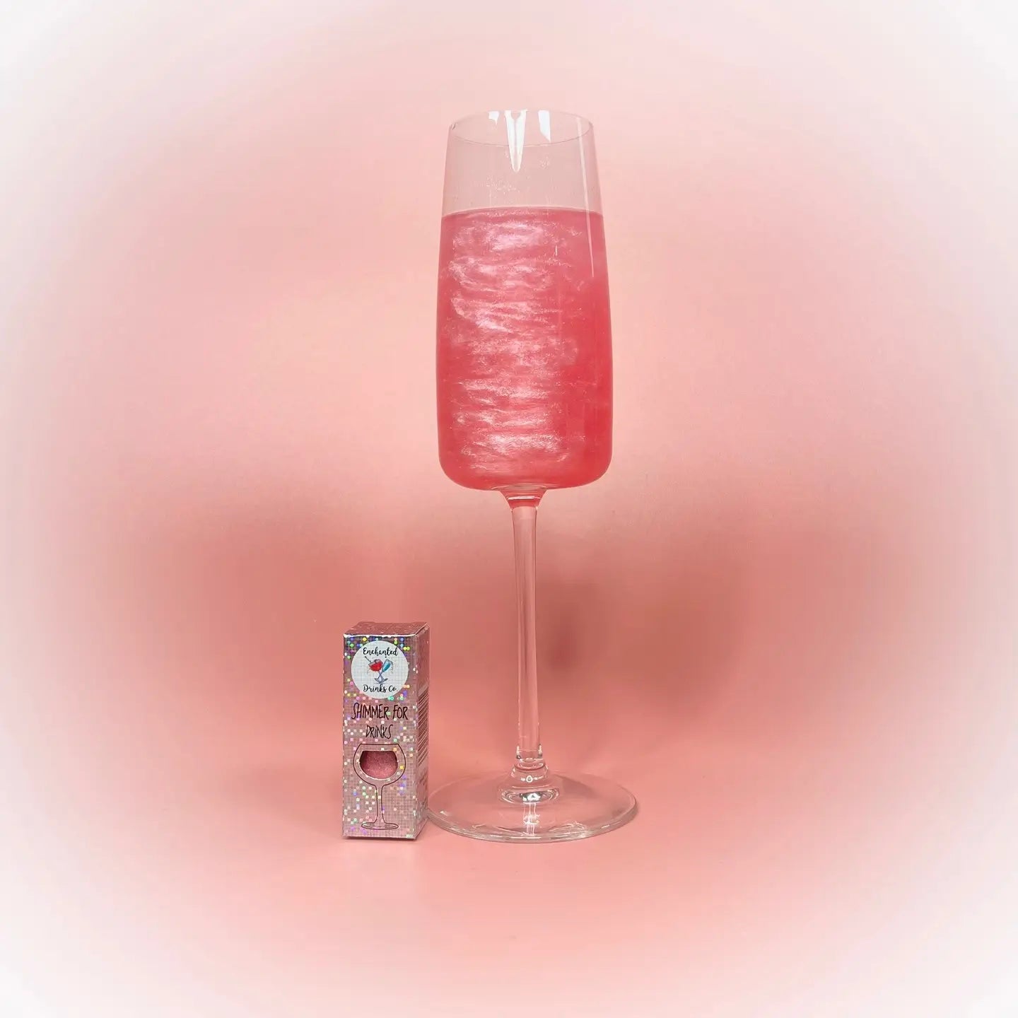 Pretty Glitter Pink Drink Shimmer Powder on display next to a sparkling pink drink in a glass.