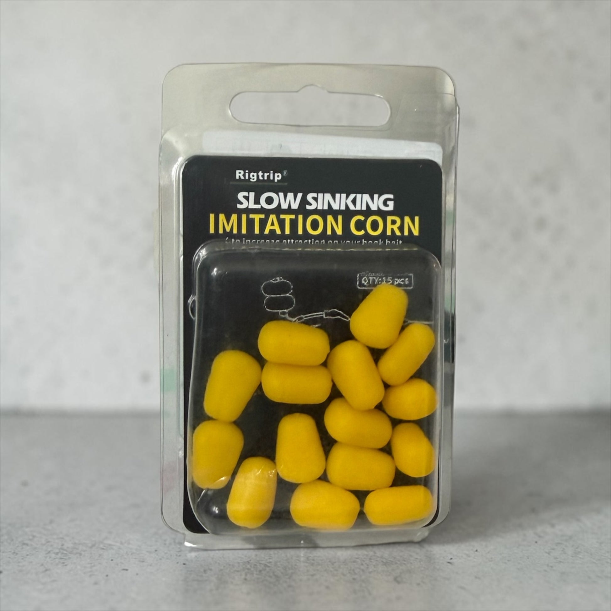 Packaged yellow imitation corn for fishing on a gray background