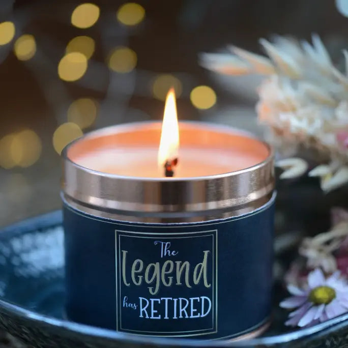 The Legend Has Retired candle with burning flame and decorative background.
