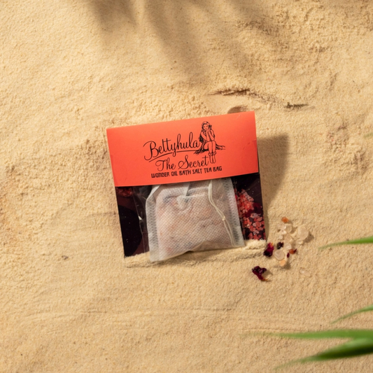 Luxurious Secret Wonder Oil Bath Salts Tea Bag on sandy background, featuring natural Himalayan salts and nourishing oils for a soothing soak.