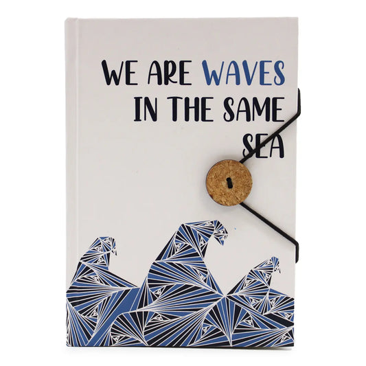 Eco-friendly notebook with 200 pages of recycled paper, strap, and coconut button closure, featuring "Waves In The Same Sea" design.