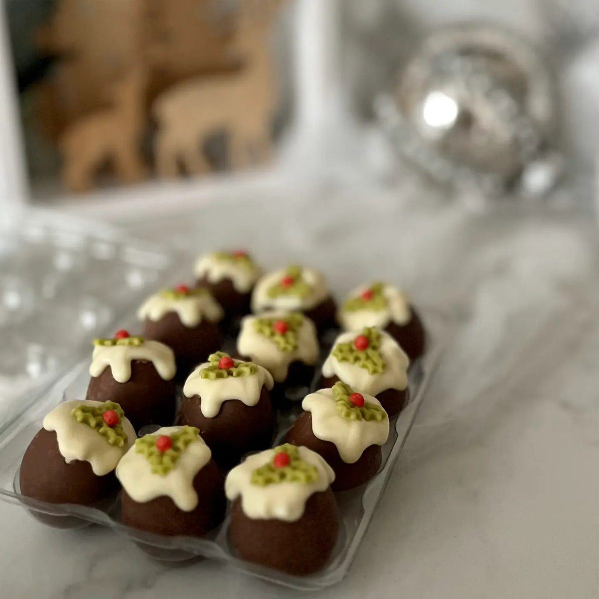 Christmas pudding-shaped chocolates made with Belgian milk and white chocolate, filled with caramel and presented in a festive box.